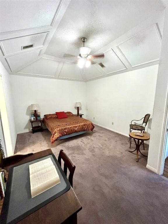 bedroom with vaulted ceiling, ceiling fan, carpet floors, and a textured ceiling