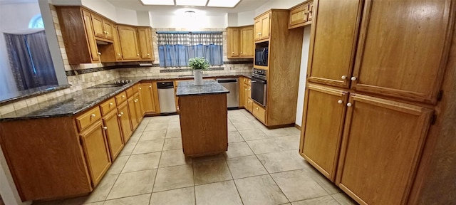 kitchen with a center island, tasteful backsplash, dark stone countertops, and black appliances