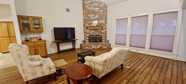 living room with a high ceiling and a brick fireplace