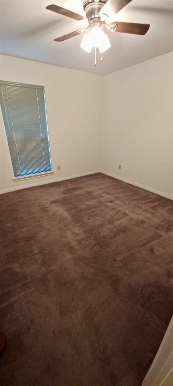 carpeted spare room featuring ceiling fan