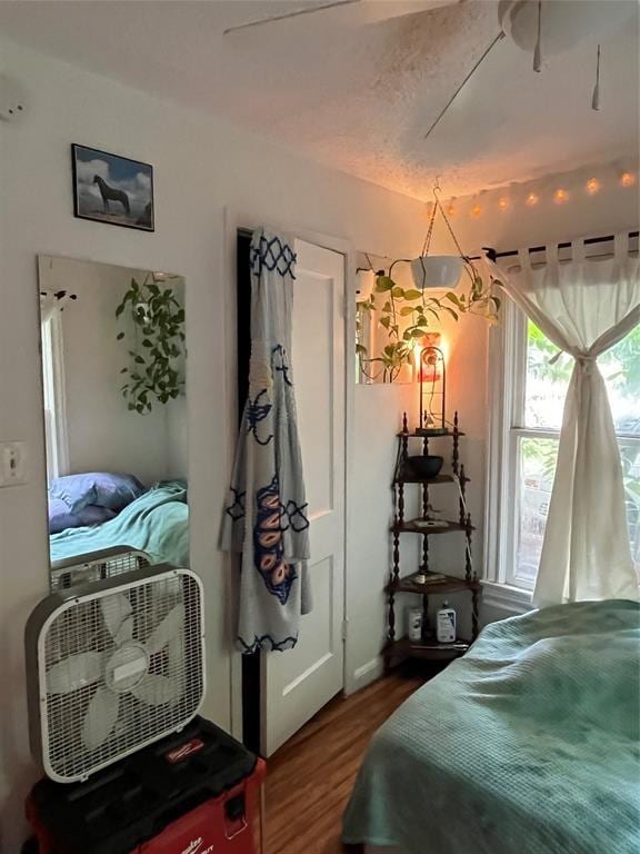 bedroom featuring wood-type flooring, a textured ceiling, and ceiling fan