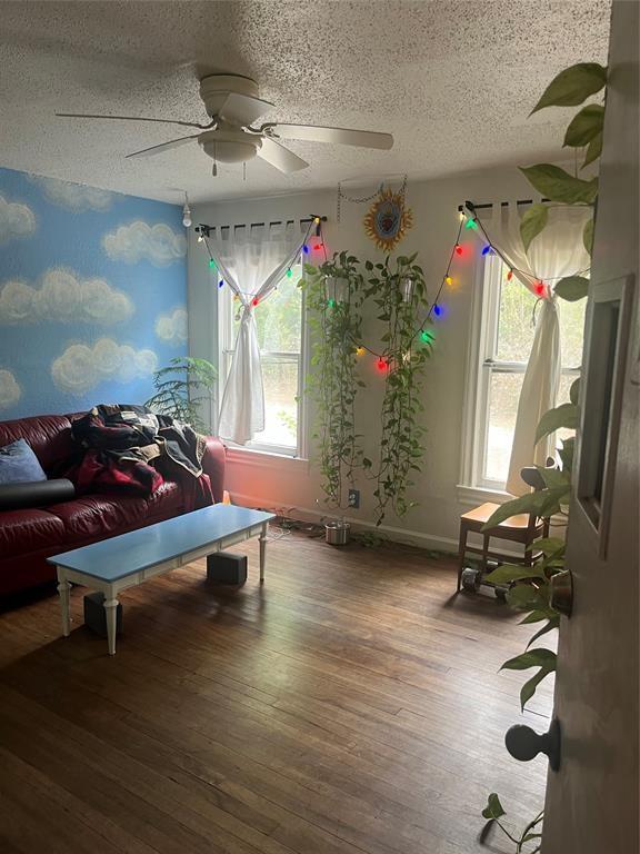 interior space with hardwood / wood-style floors, a textured ceiling, and ceiling fan