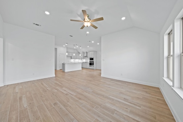 unfurnished living room featuring light hardwood / wood-style floors, vaulted ceiling, and ceiling fan