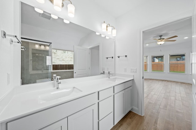 bathroom featuring tiled shower, ceiling fan, vanity, and hardwood / wood-style flooring