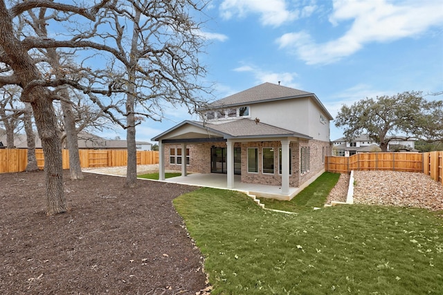 rear view of house with a lawn and a patio area