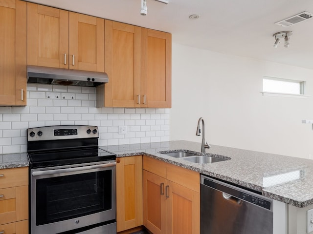 kitchen with backsplash, sink, light stone countertops, and stainless steel appliances