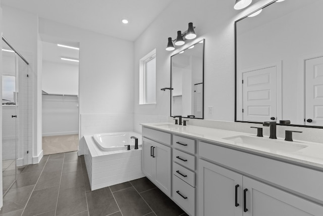 bathroom featuring plus walk in shower, vanity, and tile patterned floors