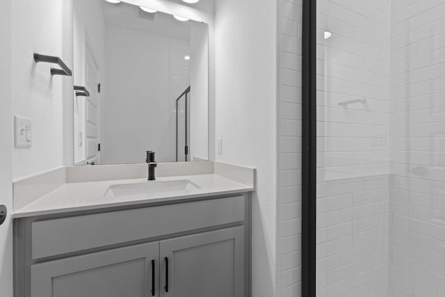 bathroom with vanity and tiled shower