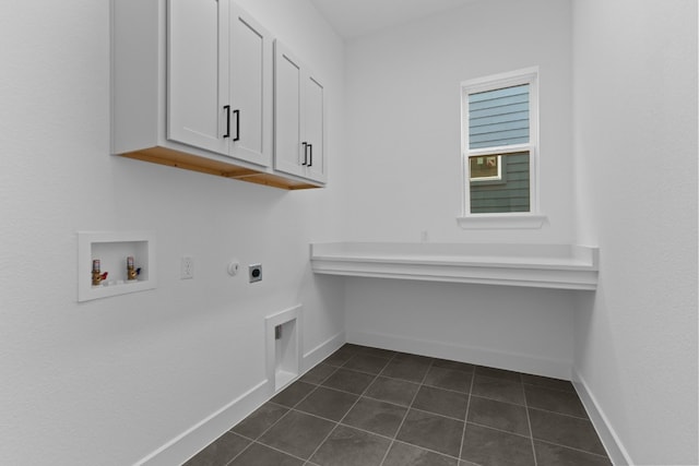 laundry room with hookup for an electric dryer, hookup for a washing machine, cabinets, and dark tile patterned floors