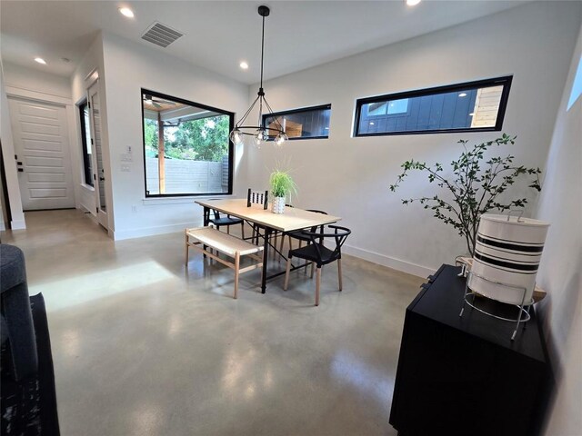 dining room featuring concrete floors and an inviting chandelier