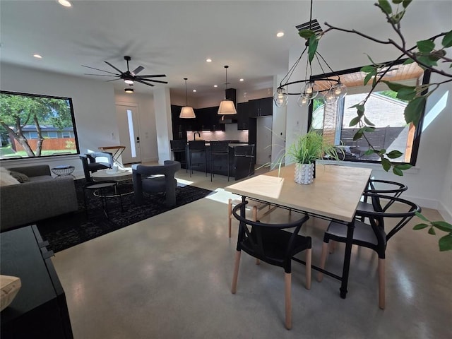 dining room with ceiling fan and concrete flooring