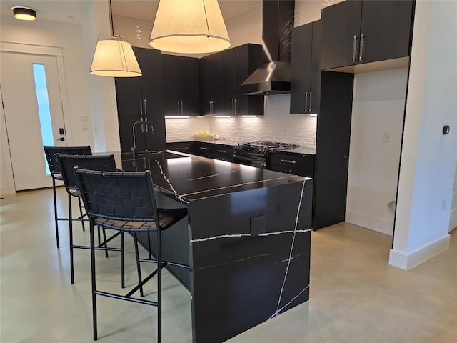 kitchen featuring decorative light fixtures, wall chimney exhaust hood, backsplash, gas range oven, and sink