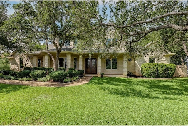 view of front of property with french doors and a front lawn