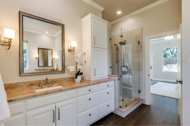 bathroom with vanity, an enclosed shower, and crown molding