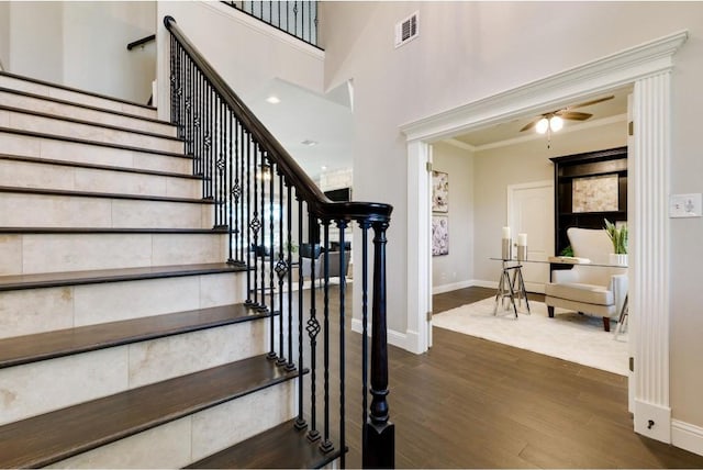 stairs featuring hardwood / wood-style floors, ceiling fan, and ornamental molding