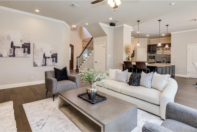 living room with ceiling fan, dark hardwood / wood-style flooring, sink, and crown molding