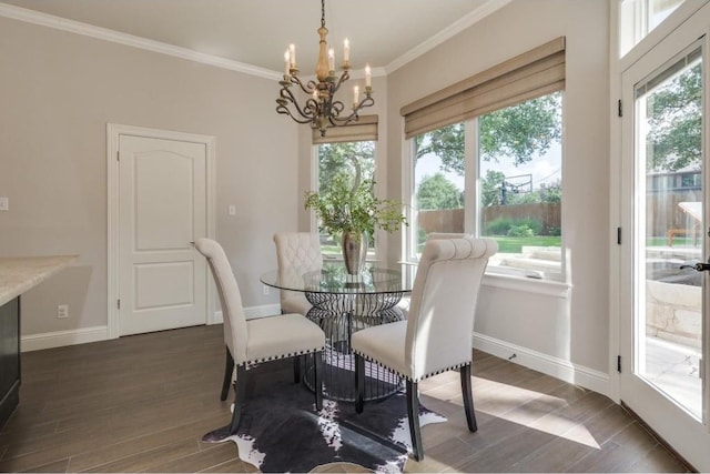 dining room with plenty of natural light, dark wood-type flooring, and an inviting chandelier