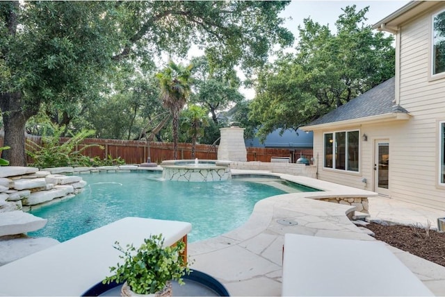 view of swimming pool with pool water feature, a patio area, and an in ground hot tub