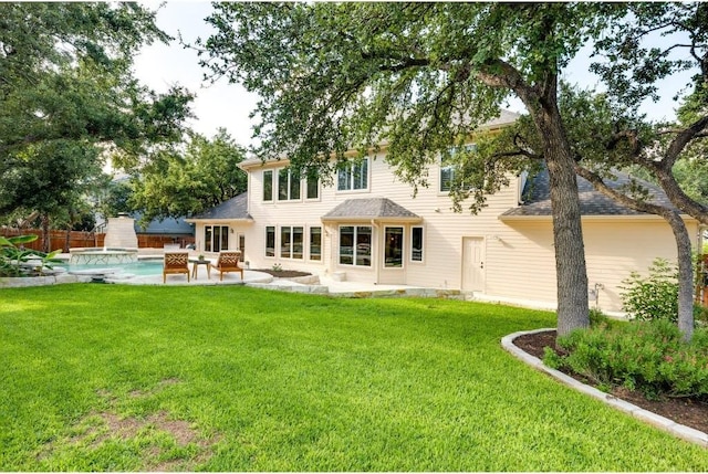 rear view of property with a yard and a patio area