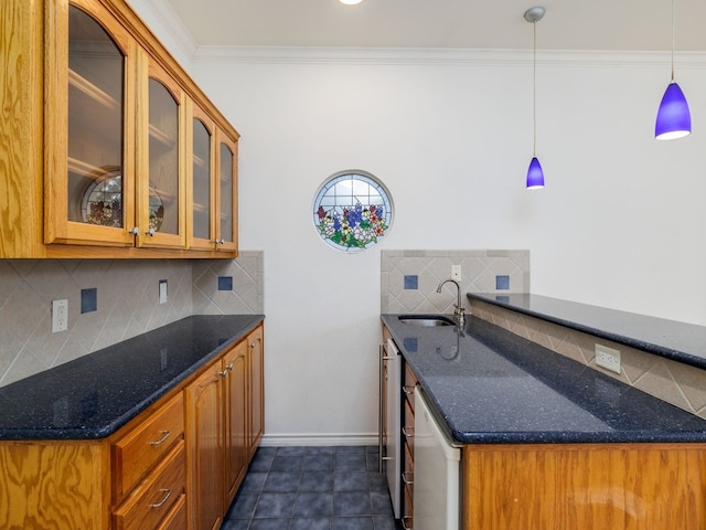 kitchen with dark stone counters, dishwashing machine, pendant lighting, backsplash, and sink