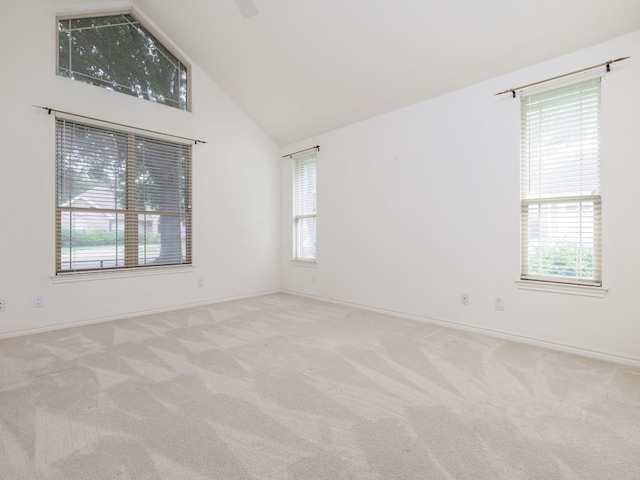 empty room featuring carpet, high vaulted ceiling, and plenty of natural light