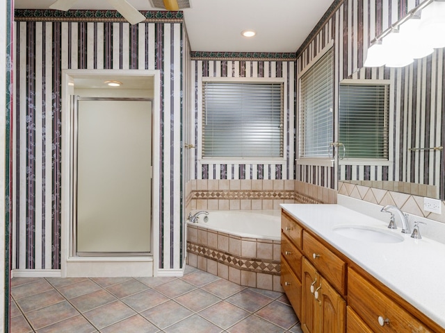 bathroom with independent shower and bath, vanity, and tile floors