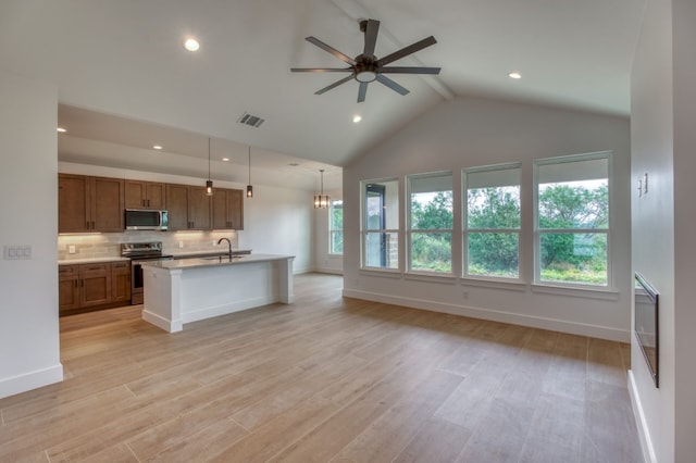 kitchen featuring sink, hanging light fixtures, stainless steel appliances, an island with sink, and ceiling fan with notable chandelier