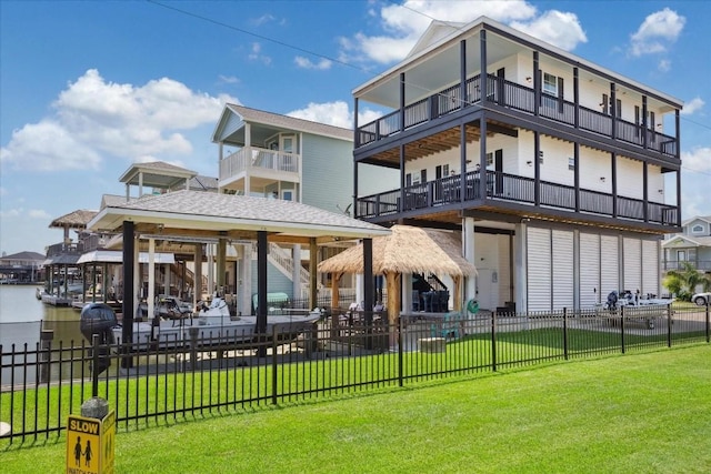 back of property with a gazebo, a yard, and a water view