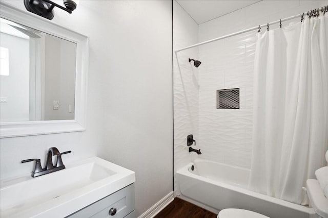 full bathroom featuring hardwood / wood-style flooring, shower / tub combo with curtain, vanity, and toilet