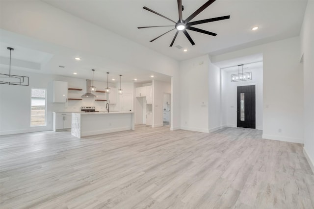 unfurnished living room with ceiling fan and light hardwood / wood-style flooring