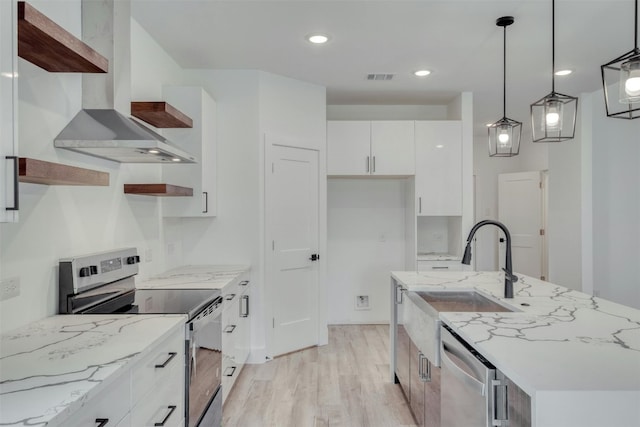 kitchen featuring light stone countertops, appliances with stainless steel finishes, exhaust hood, decorative light fixtures, and white cabinets