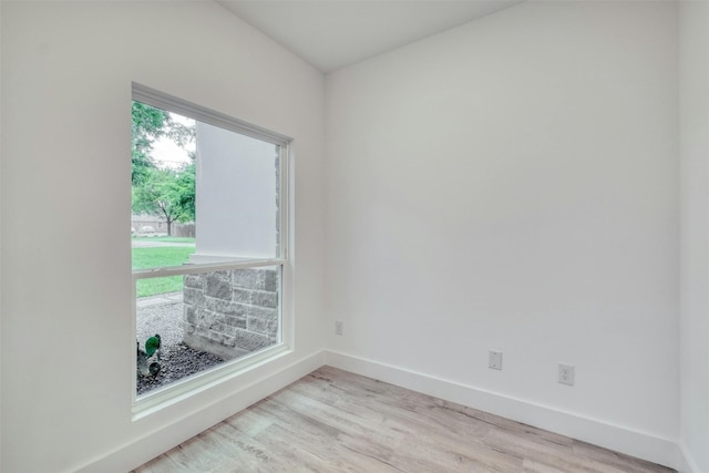 spare room with a wealth of natural light and light hardwood / wood-style flooring