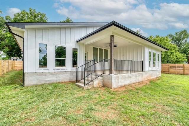 back of house with a lawn and ceiling fan