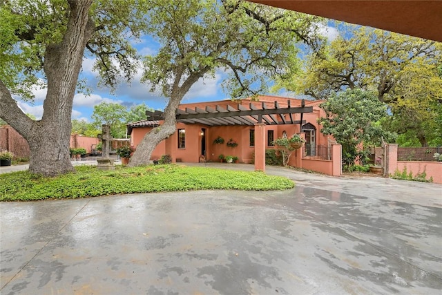 mediterranean / spanish home featuring a tile roof, a pergola, stucco siding, and fence