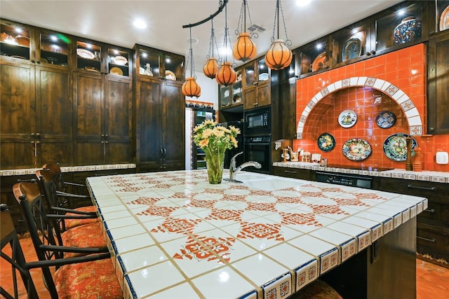 interior space with black appliances, a sink, tile counters, and tasteful backsplash