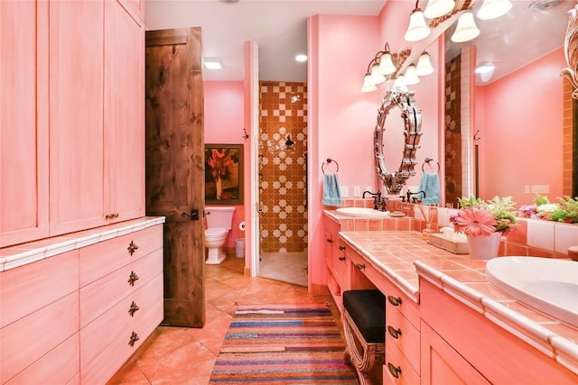full bathroom featuring double vanity, toilet, a shower stall, and a sink