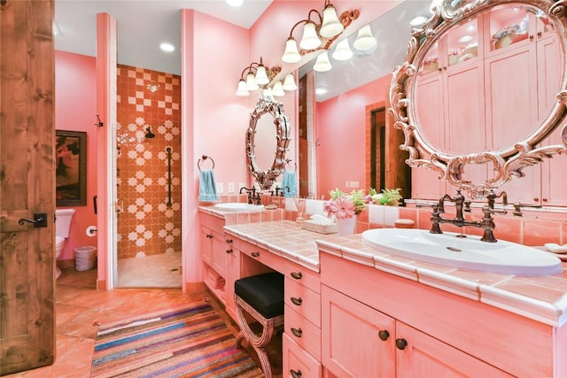 bathroom featuring a stall shower, double vanity, a sink, and tile patterned floors