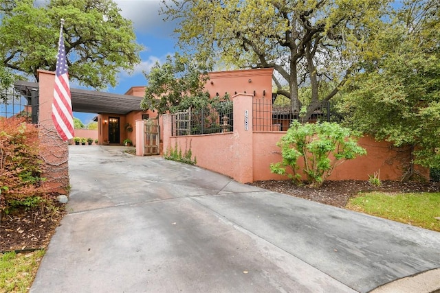 view of home's exterior featuring stucco siding, driveway, and a fenced front yard