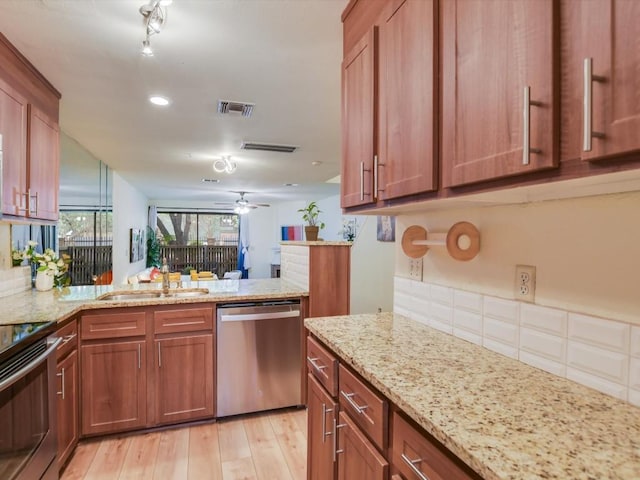 kitchen featuring a sink, light wood-style floors, stainless steel dishwasher, and brown cabinetry