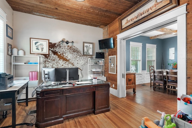 office space featuring beam ceiling, light hardwood / wood-style floors, and wooden ceiling