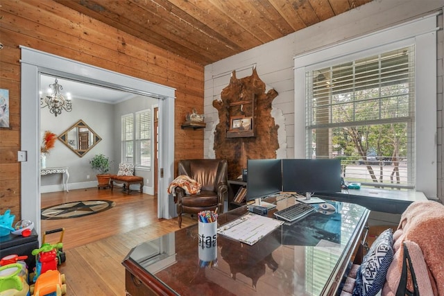 home office with hardwood / wood-style floors, a notable chandelier, ornamental molding, wooden ceiling, and wood walls