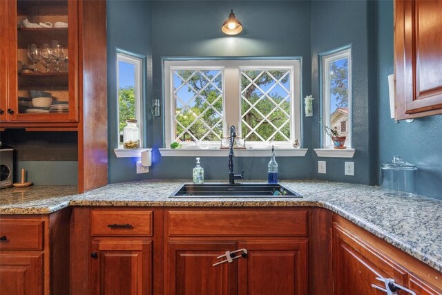 kitchen featuring plenty of natural light, sink, and light stone counters