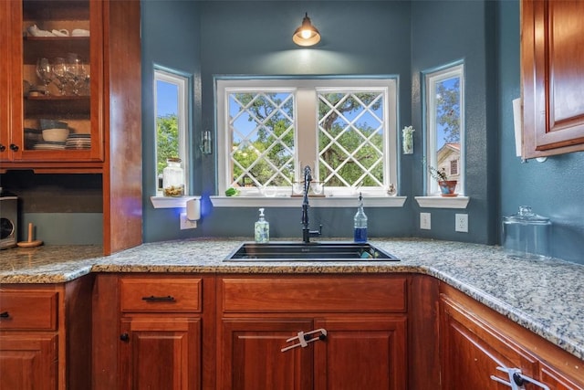 kitchen featuring light stone countertops and sink