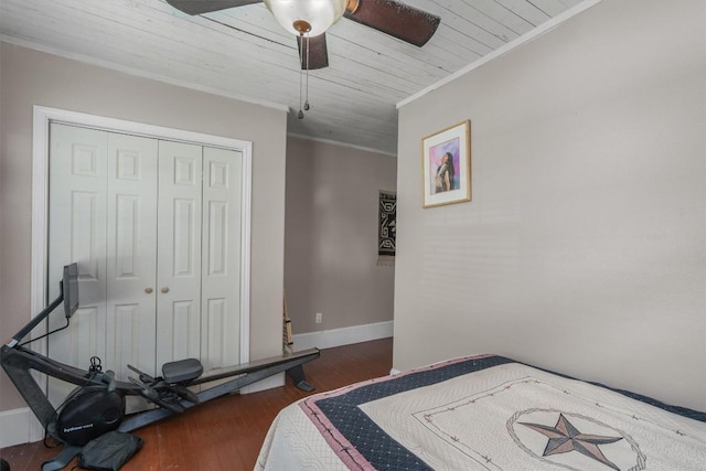 bedroom featuring dark wood-type flooring, ceiling fan, crown molding, and a closet