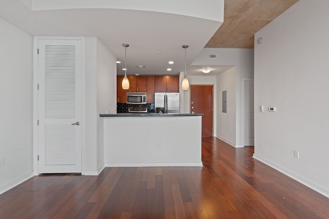 kitchen featuring decorative backsplash, stainless steel appliances, dark wood-type flooring, electric panel, and hanging light fixtures