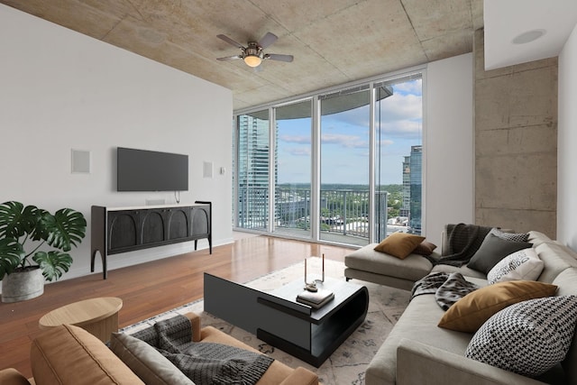 living room with ceiling fan, expansive windows, and light hardwood / wood-style flooring