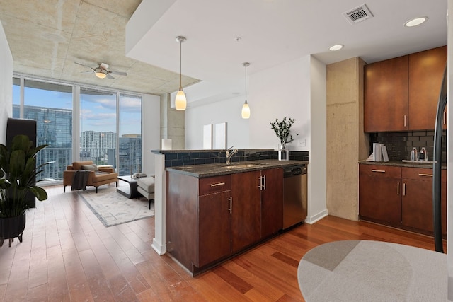 kitchen with floor to ceiling windows, ceiling fan, dishwasher, backsplash, and hardwood / wood-style flooring