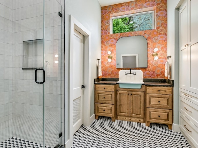 bathroom featuring a shower with shower door and vanity