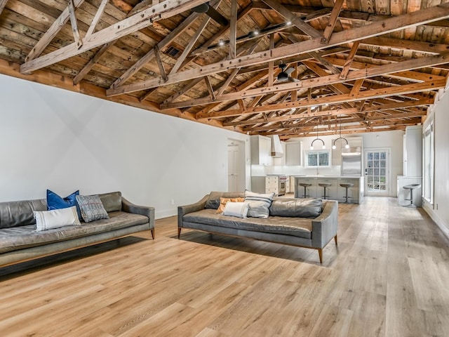 living room with light hardwood / wood-style floors, lofted ceiling with beams, and wooden ceiling