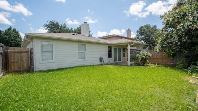 rear view of house featuring a lawn